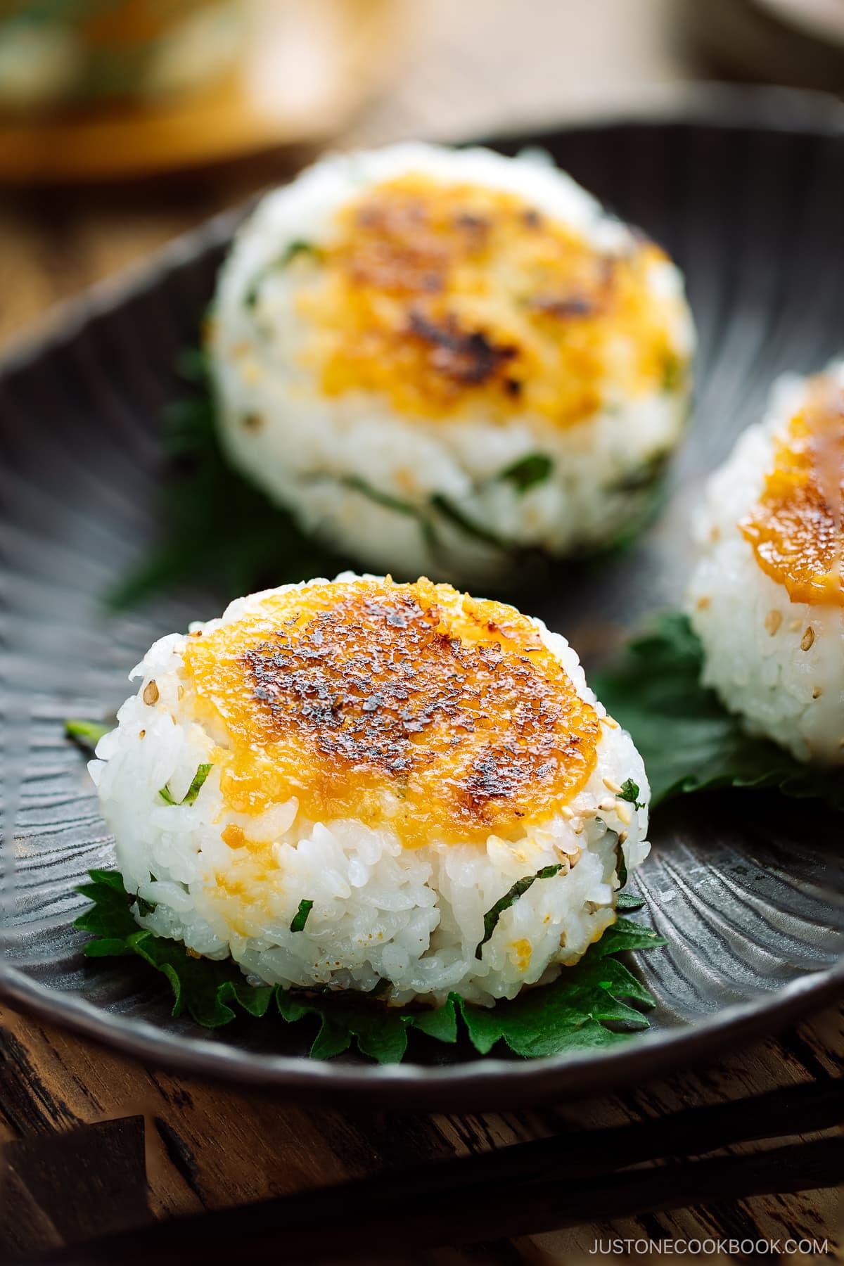 Miso Yaki Onigiri placed on a bizenware ceramic plate garnished with shiso leaf.