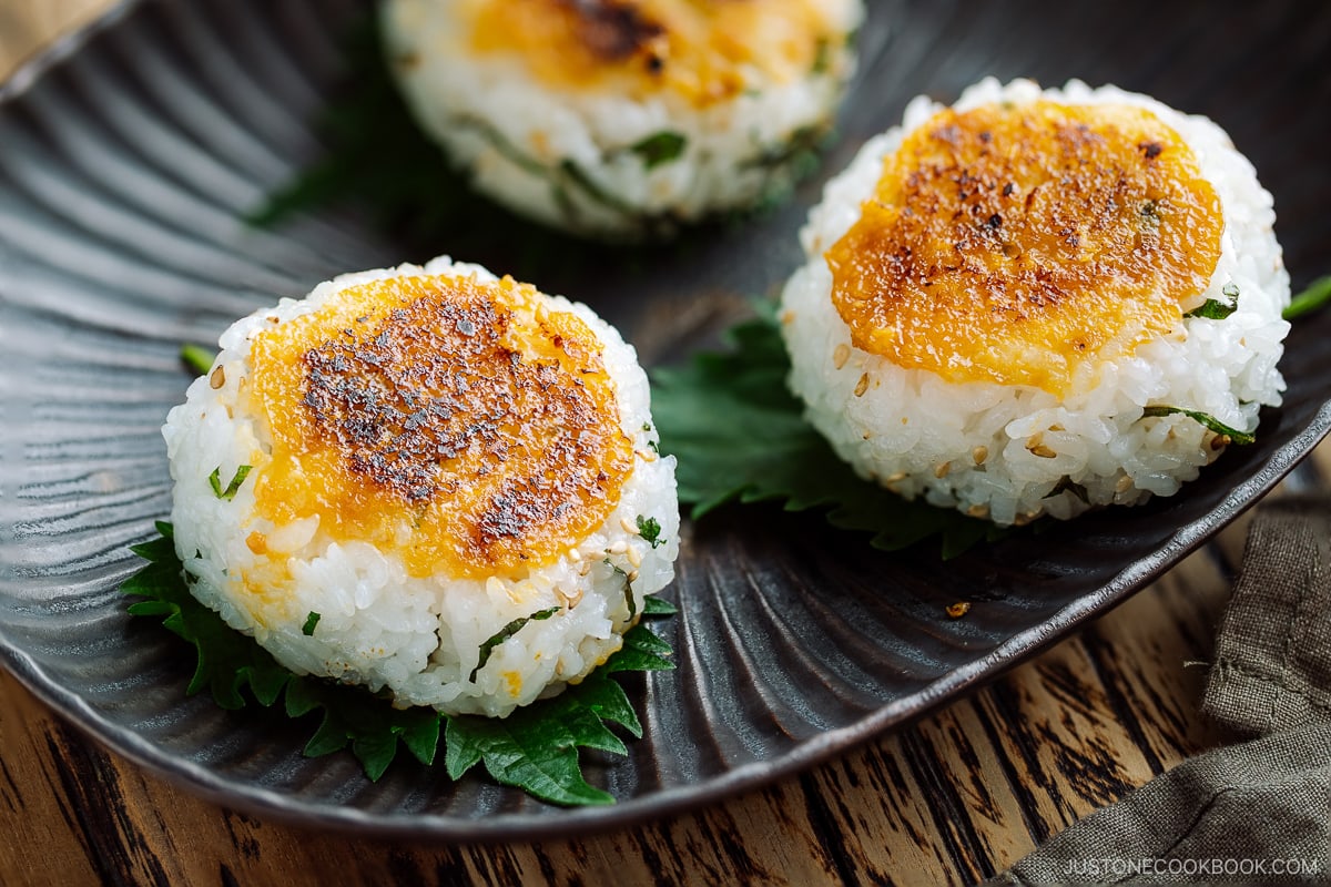 Miso Yaki Onigiri placed on a bizenware ceramic plate garnished with shiso leaf.