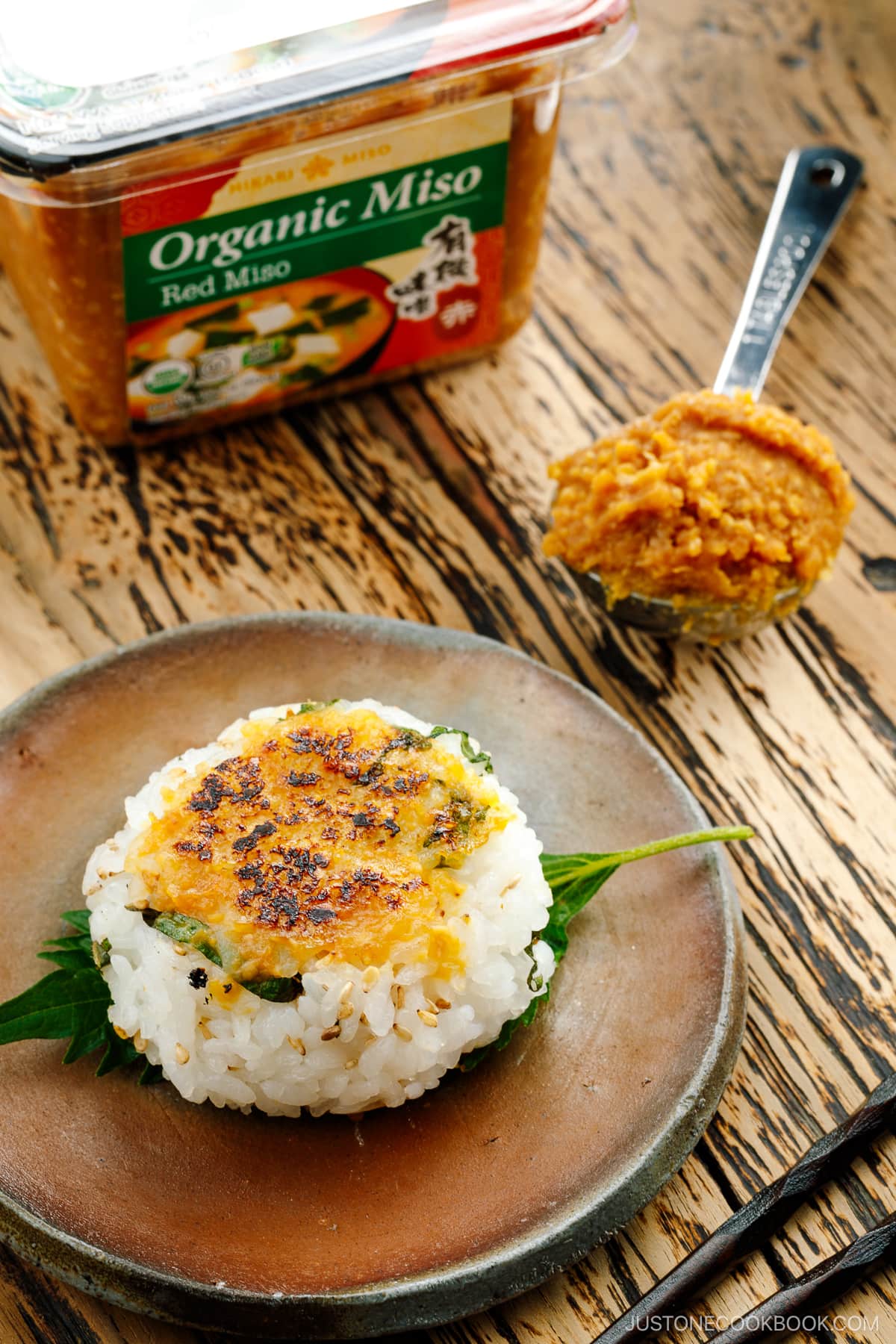 Miso Yaki Onigiri placed on a bizenware ceramic plate garnished with shiso leaf.