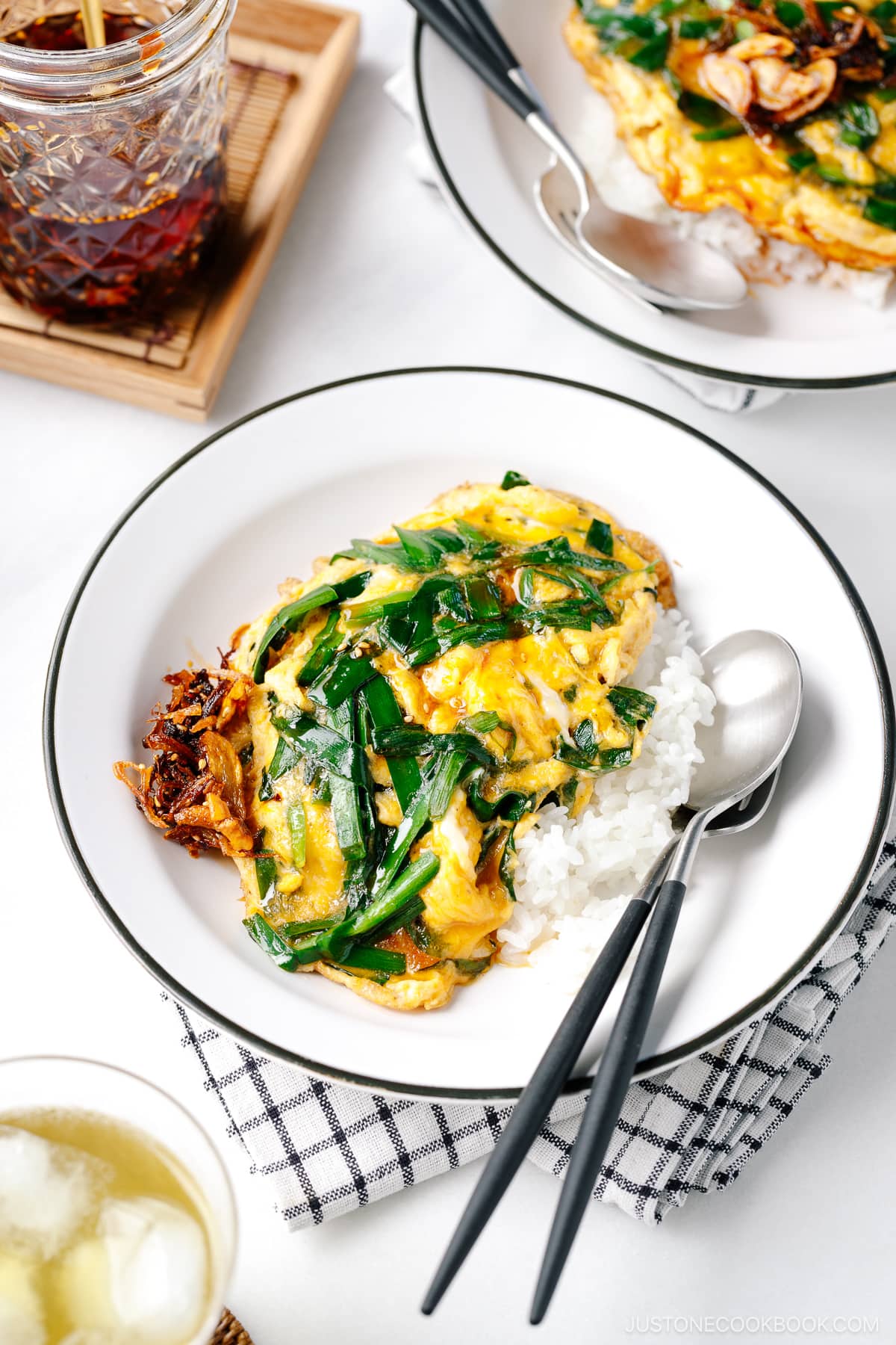 A white plate containing Stir-Fried Garlic Chives and Egg Over Rice.