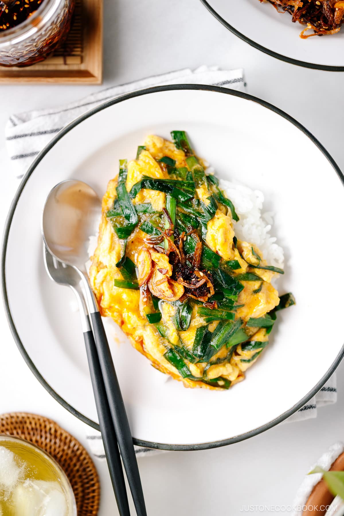 A white plate containing Stir-Fried Garlic Chives and Egg Over Rice.