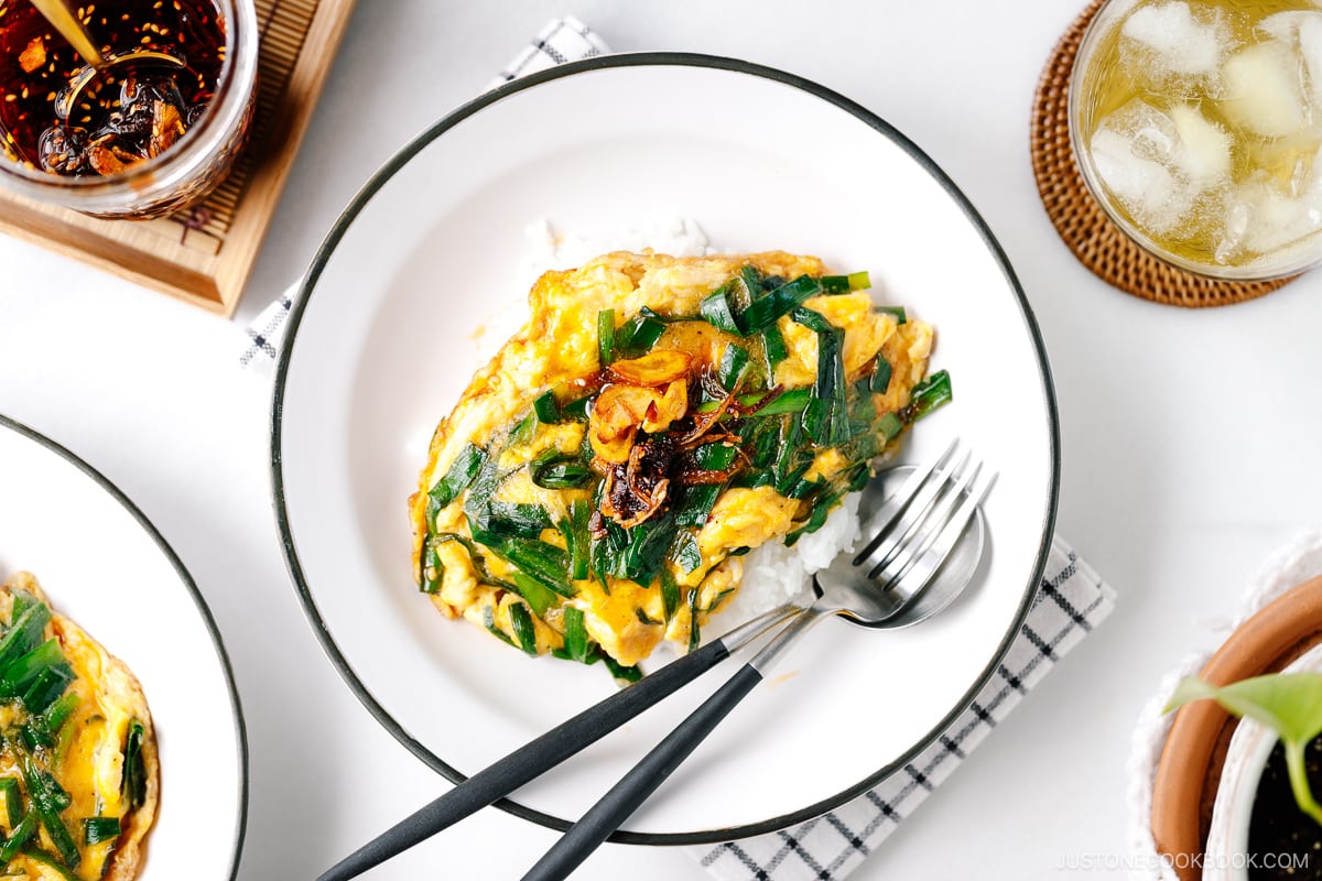 A white plate containing Stir-Fried Garlic Chives and Egg Over Rice.