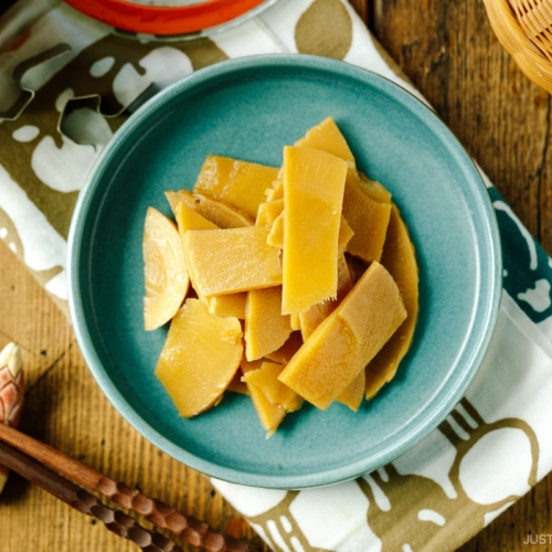 A blue plate containing menma, seasoned bamboo shoots for ramen.