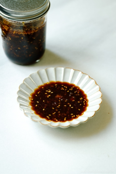 A mason jar and a fluted plate containing Homemade yakiniku sauce (Japanese BBQ sauce) .