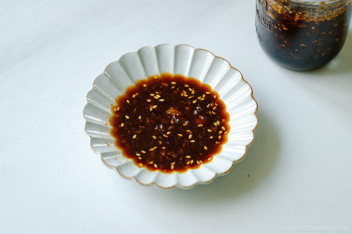 A mason jar and a fluted plate containing Homemade yakiniku sauce (Japanese BBQ sauce) .
