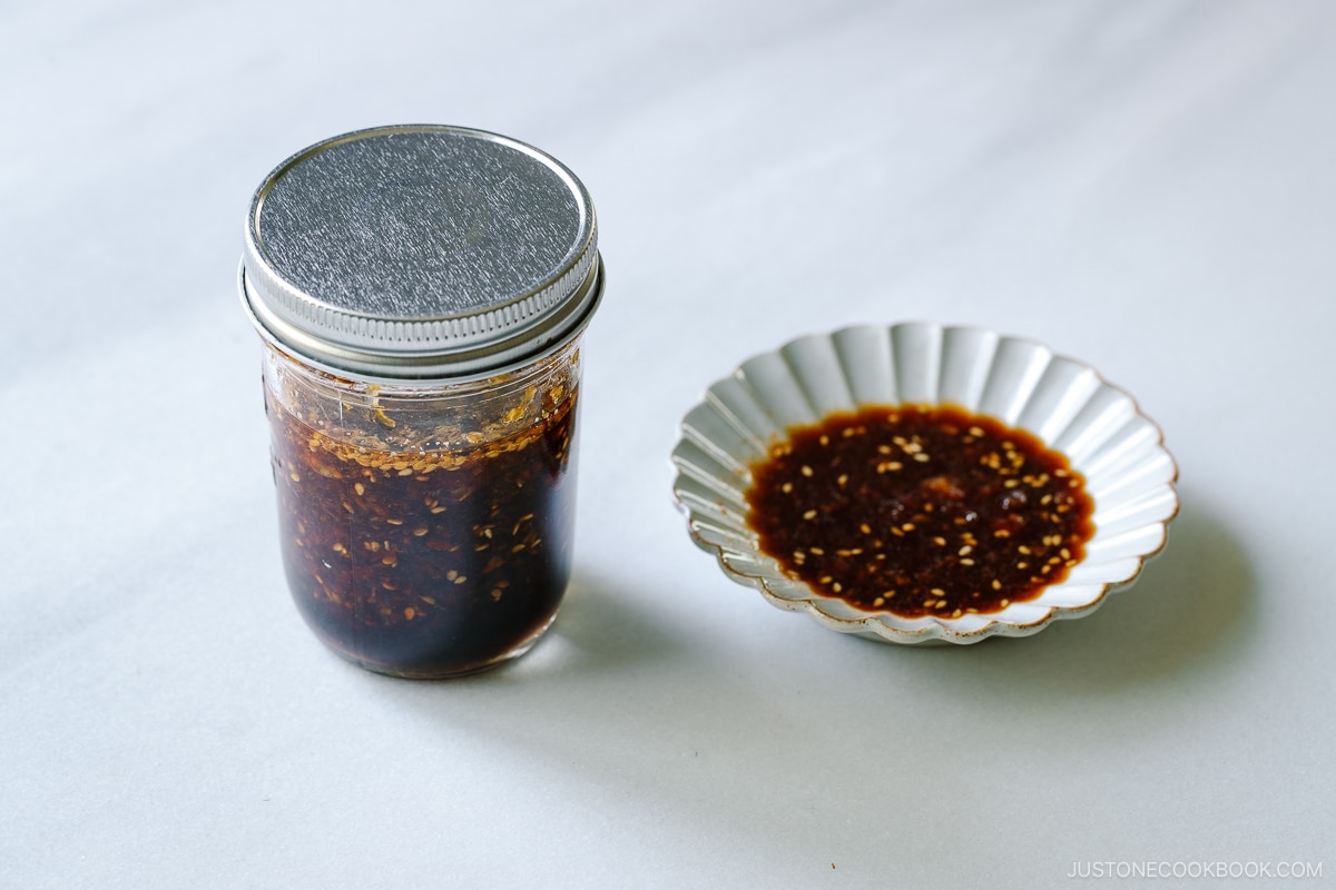 A mason jar and a fluted plate containing Homemade yakiniku sauce (Japanese BBQ sauce) .