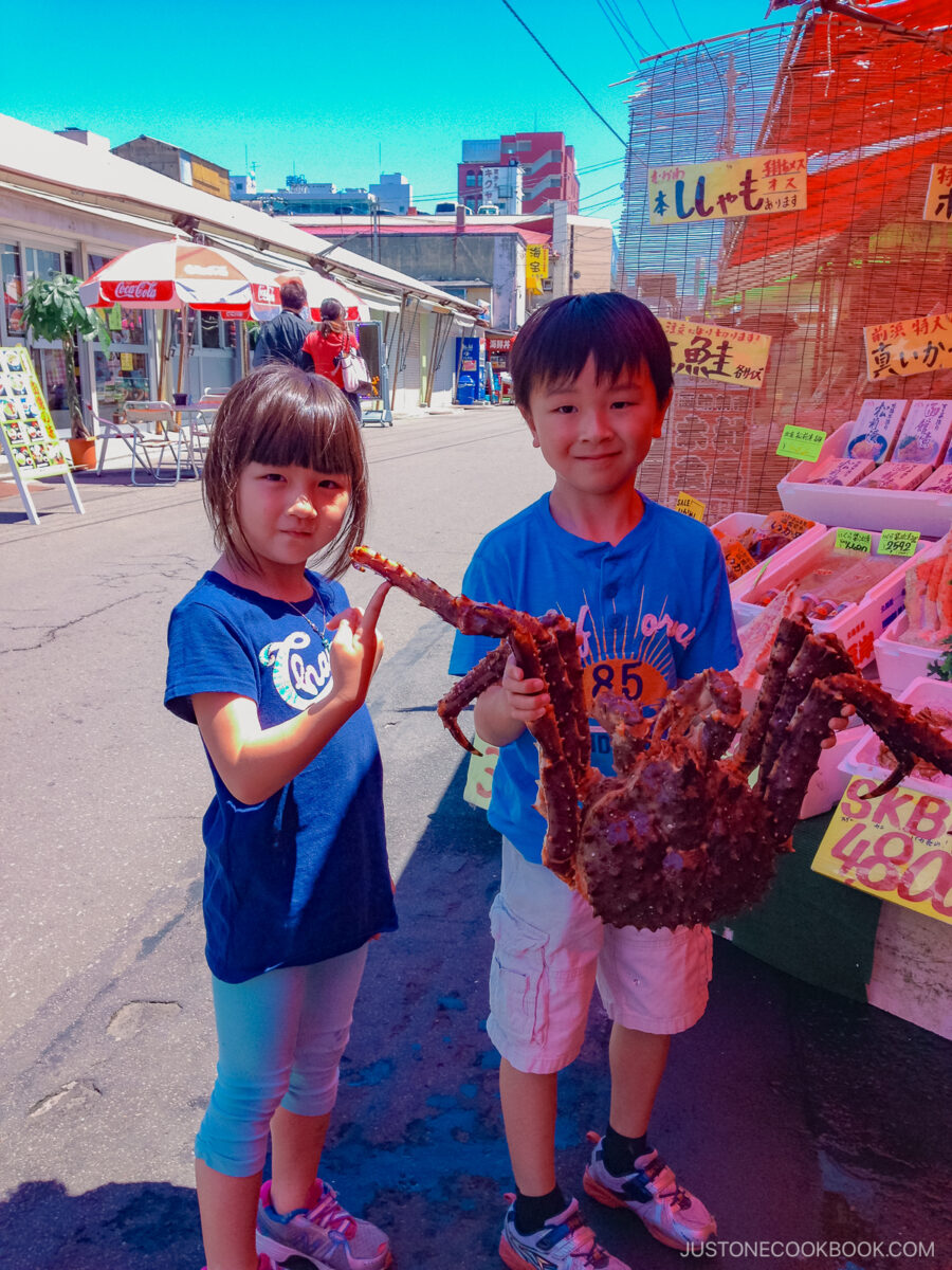 a boy holding a large crab in his hands