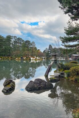 a stone lantern in a large pond at Kenroku-e