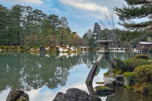 a stone lantern in a large pond at Kenroku-e