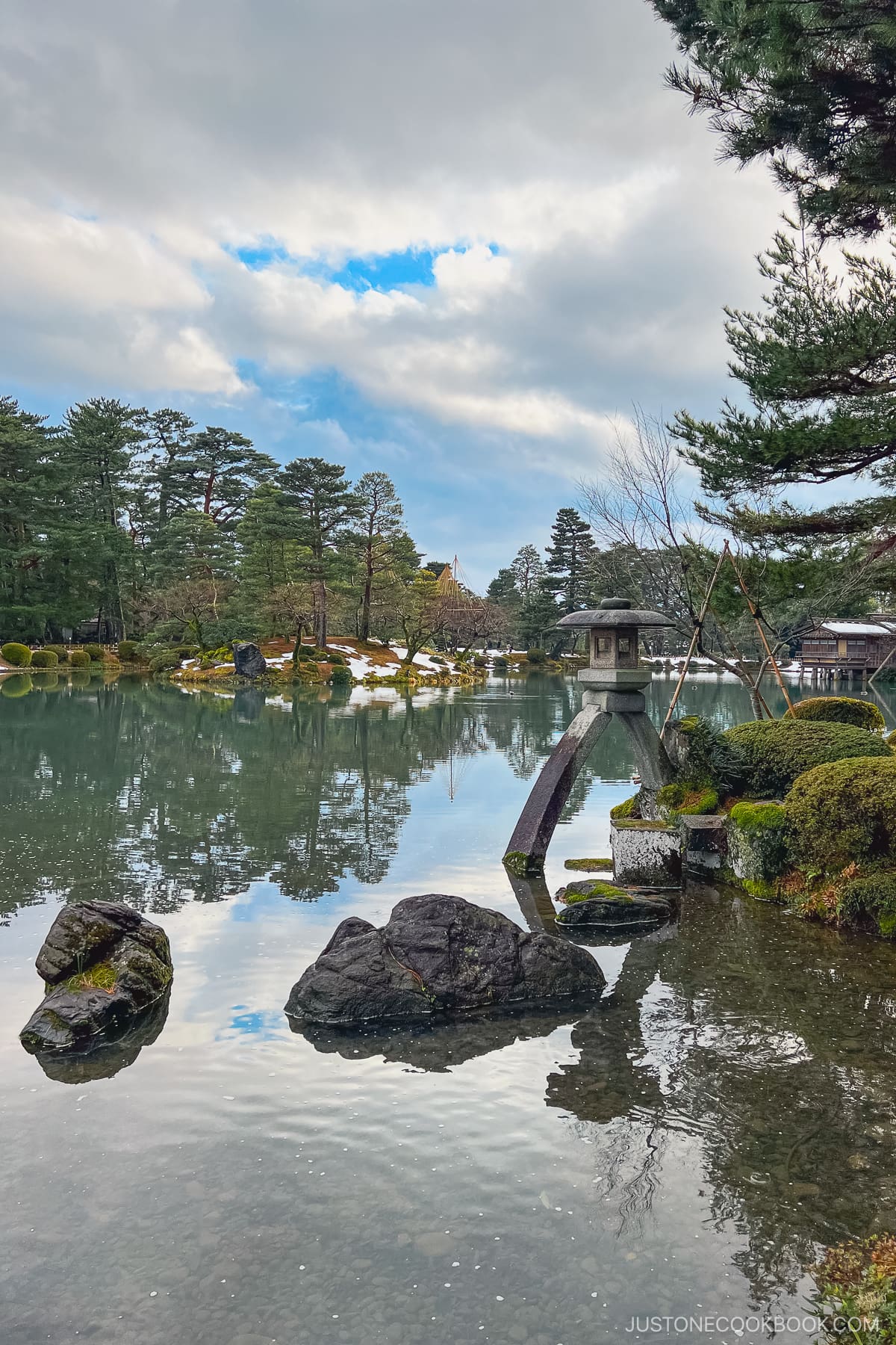 a stone lantern in a large pond at Kenroku-e