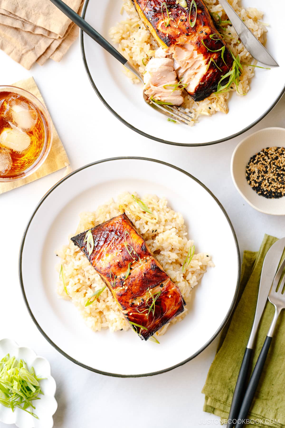 White plates containing Broiled Miso Salmon served over ginger rice.