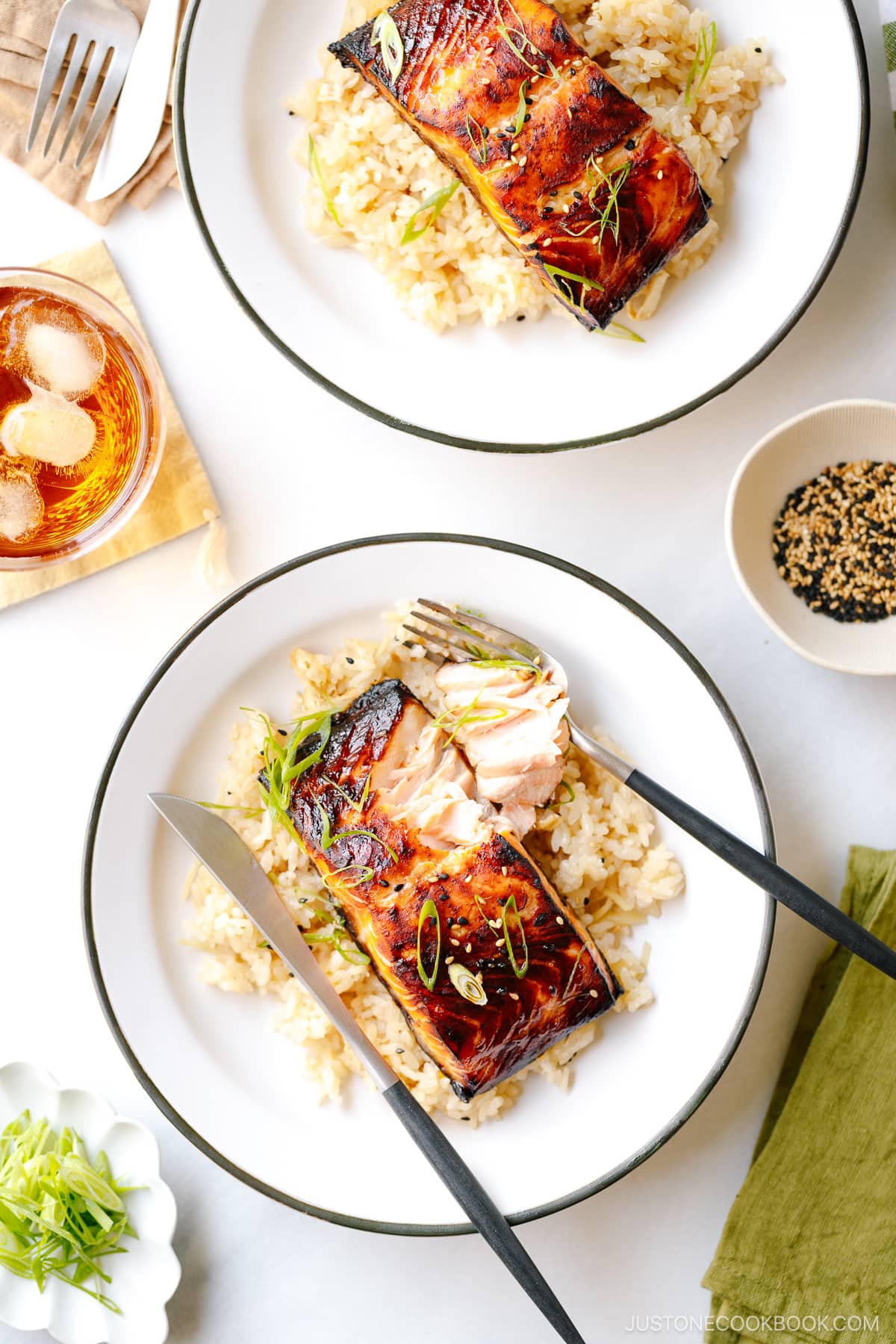 White plates containing Broiled Miso Salmon served over ginger rice.
