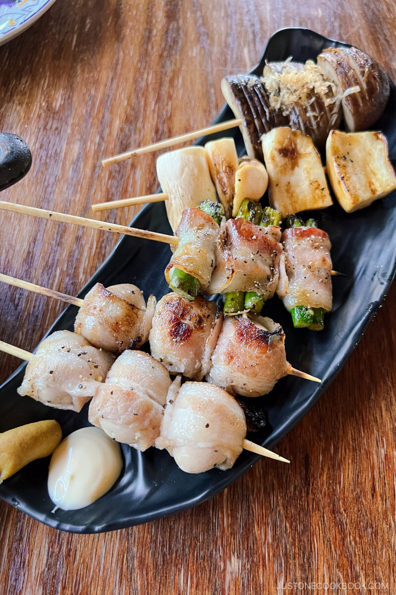 assorted skewers on a black plate