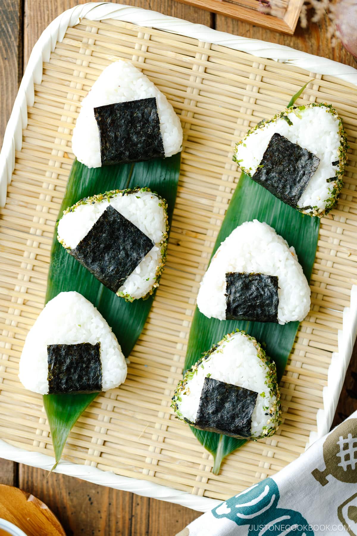 A bamboo basket containing 6 onigiri (Japanese rice balls).