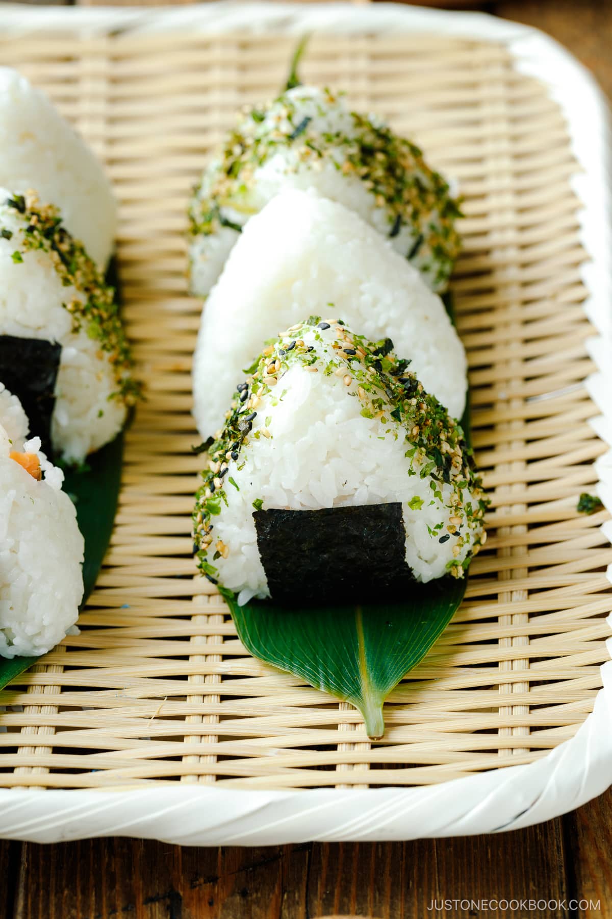 A bamboo basket containing 6 onigiri (Japanese rice balls).