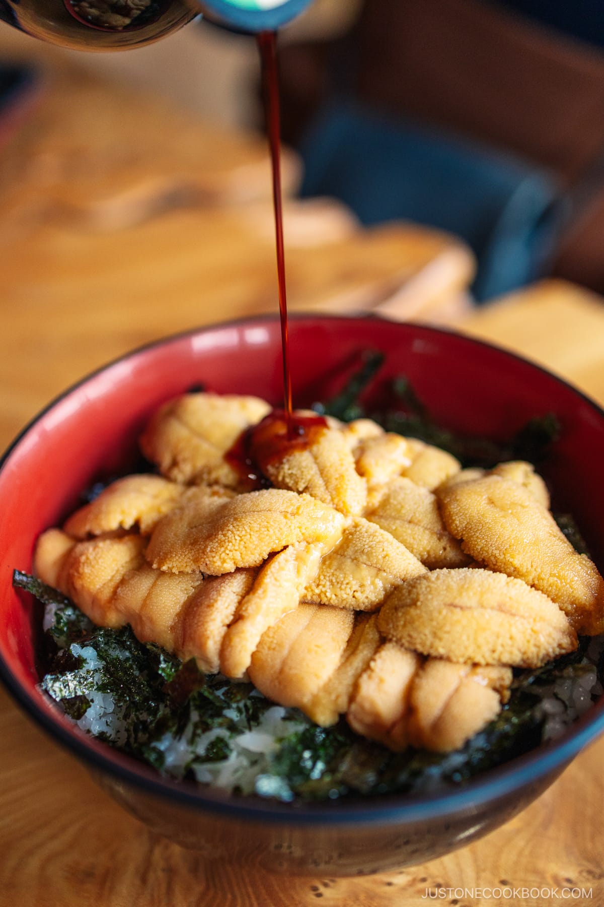 Soy sauce being poured on the sea urchin