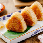 A rectangular plate containing Yaki Onigiri (Grilled Rice Balls).