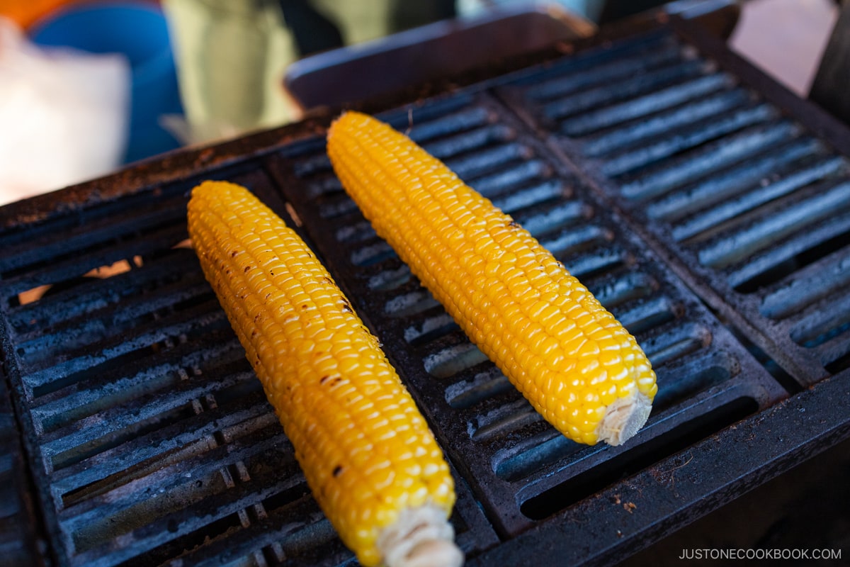 Hokkaido sweet corn cooking on an iron grill