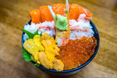 uni, crab, ikura, and salmon on a bowl of rice