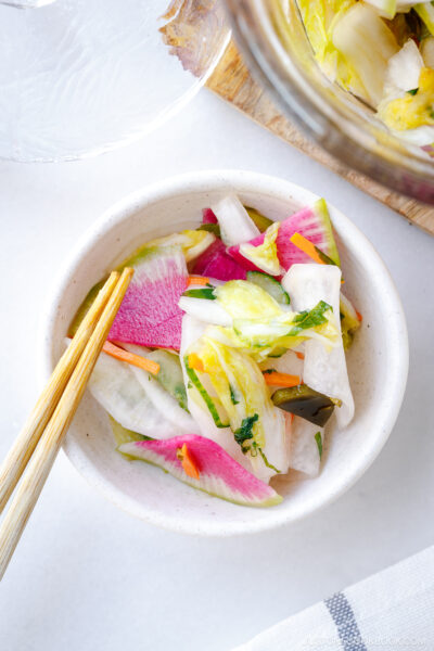 A white small dish containing colorful Japanese Pickles.