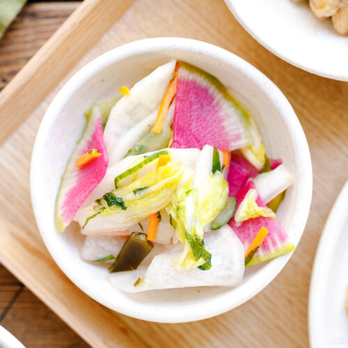 A white small dish containing colorful Japanese Pickles.