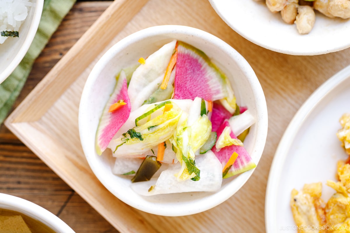 A white small dish containing colorful Japanese Pickles.