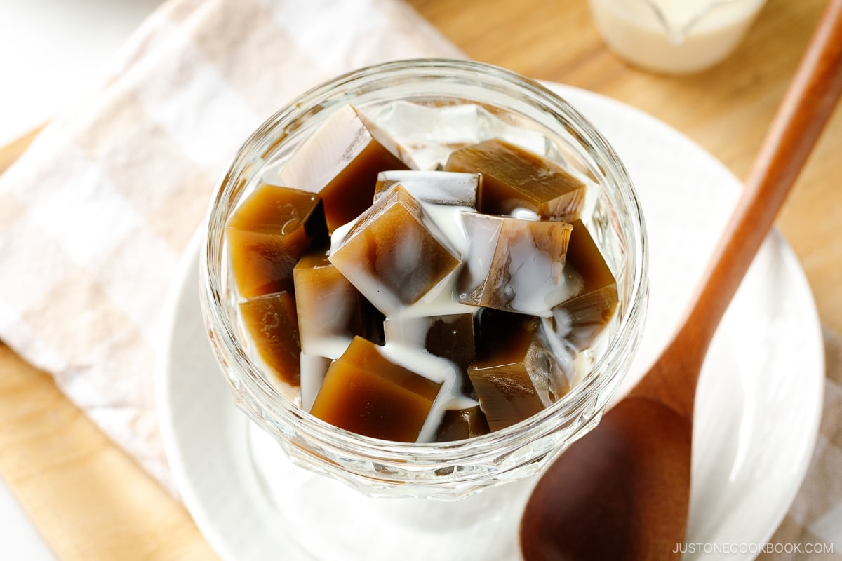 A glass bowl containing cubed Hojicha Jelly drizzled with sweetened condensed milk.