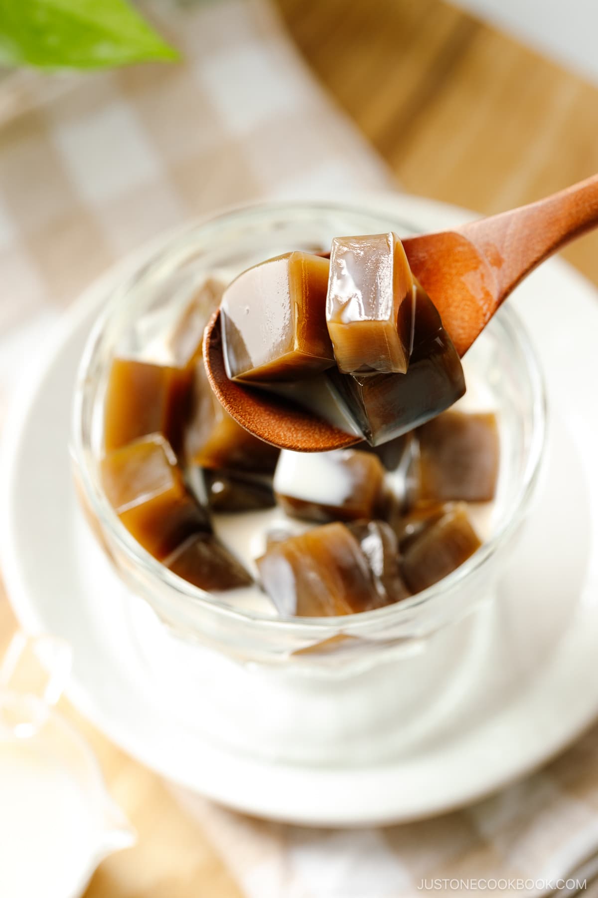 A glass bowl containing cubed Hojicha Jelly drizzled with sweetened condensed milk.