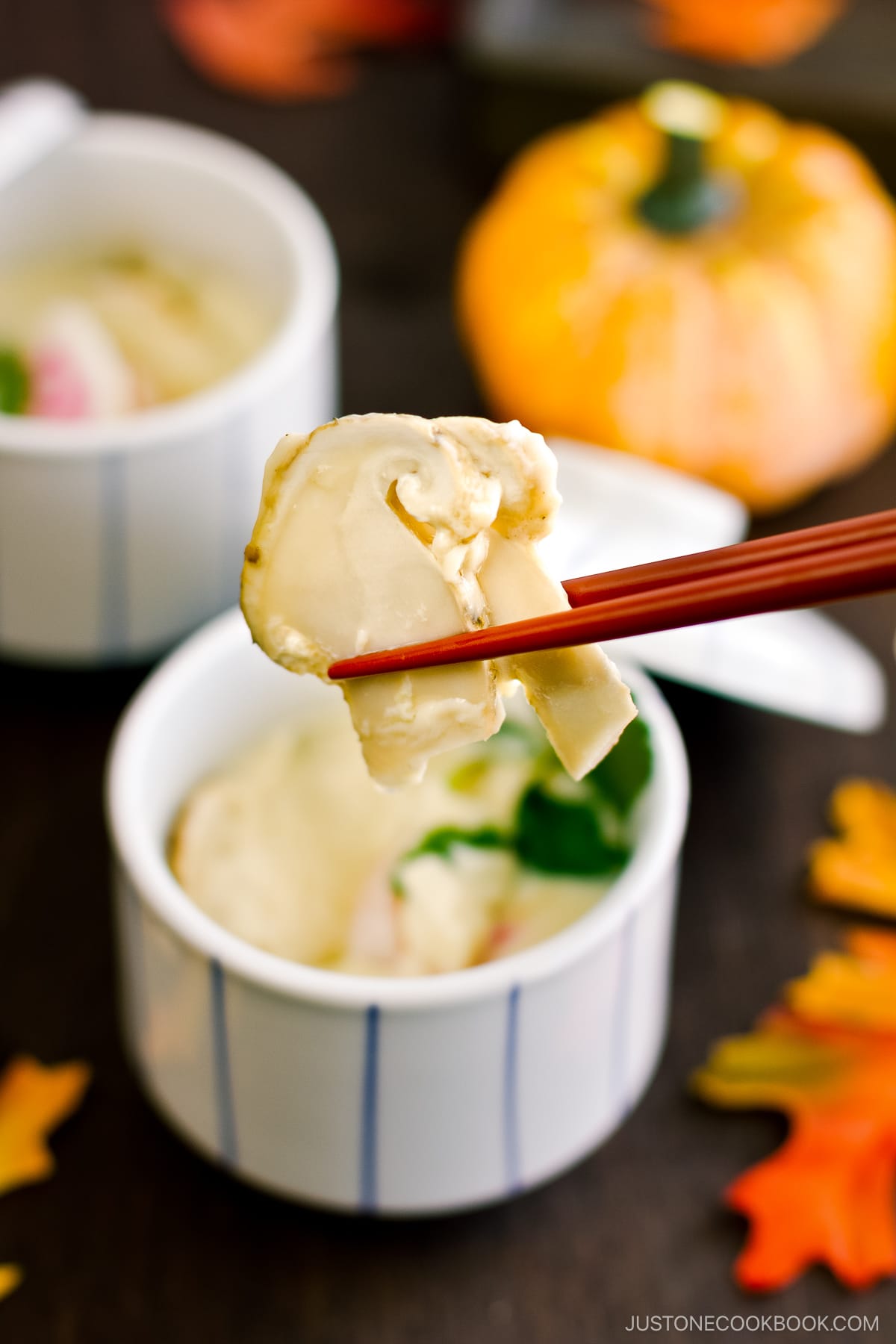 Chawanmushi cups containing matsutake mushrooms, shrimp, and fish cake slices in a savory steamed egg mixture.