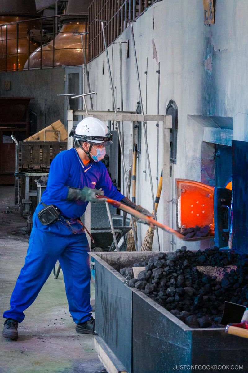 Worker adding more coal to the fires