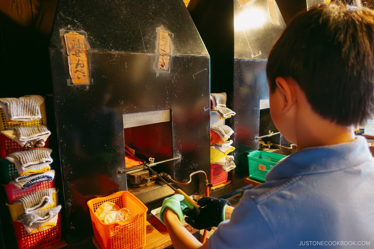 children making their own rice crackers in front of the oven