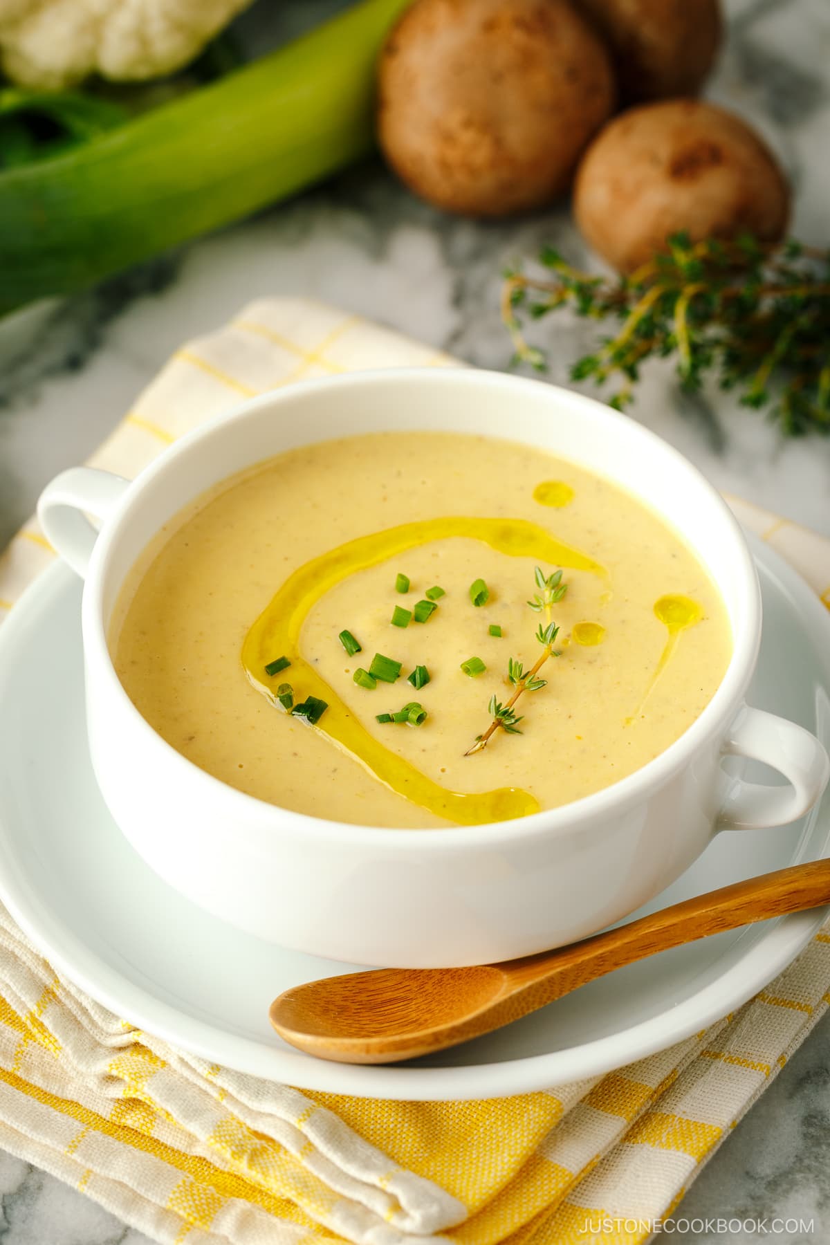 A white soup bowl containing Creamy Roasted Cauliflower Soup.