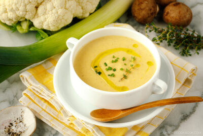 A white soup bowl containing Creamy Roasted Cauliflower Soup.
