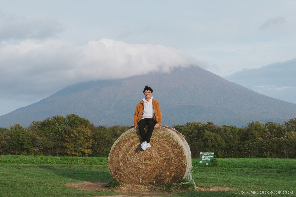 Sitting on a hay bale in front of Mt Yotei