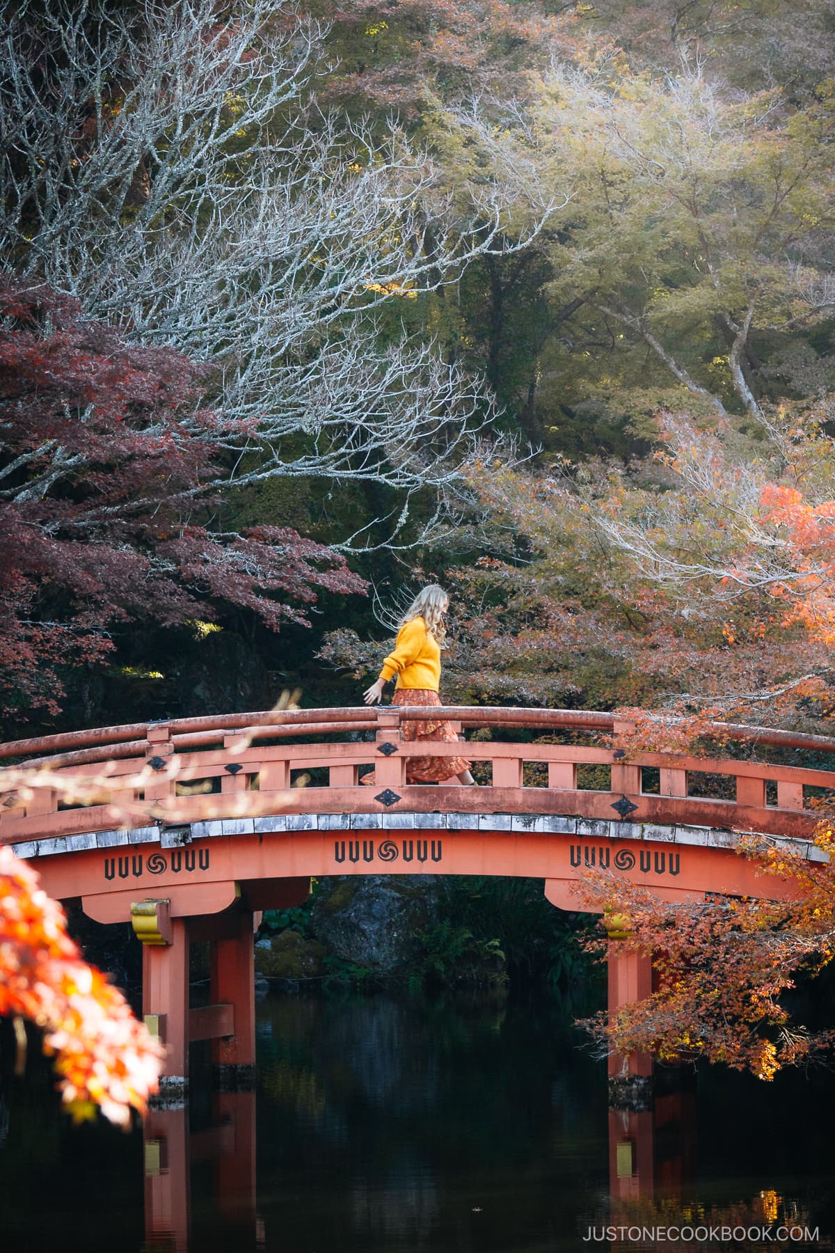 Woman walking across a red bridge