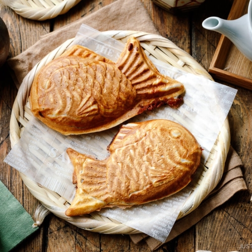 Taiyaki, Japanese fish-shaped cakes, placed on a woven basket lined with a parchment paper.