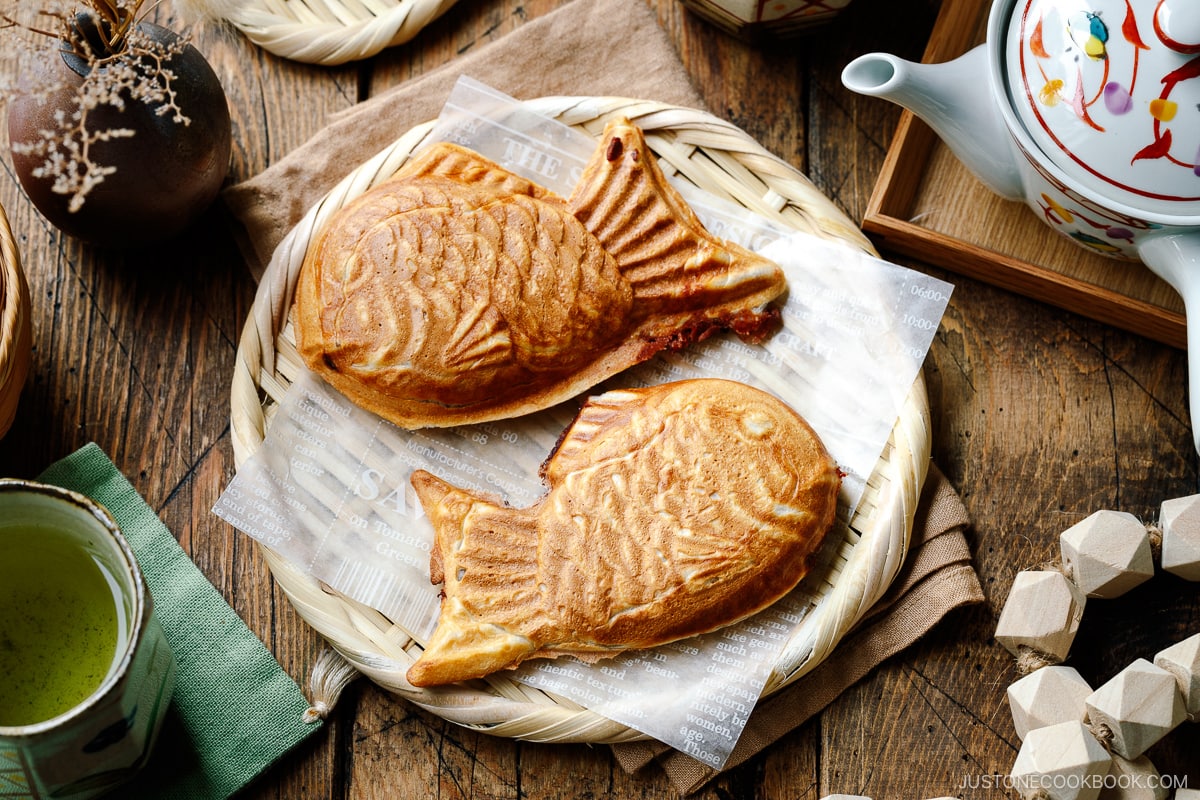 Taiyaki, Japanese fish-shaped cakes, placed on a woven basket lined with a parchment paper.