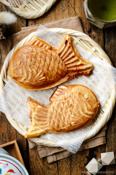Taiyaki, Japanese fish-shaped cakes, placed on a woven basket lined with a parchment paper.