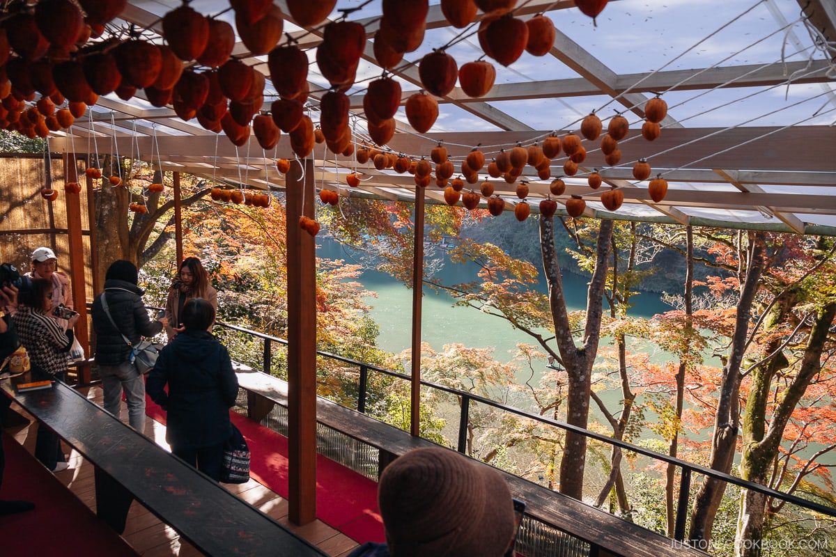 Wooden terrace with hanging persimmons overlooking a river