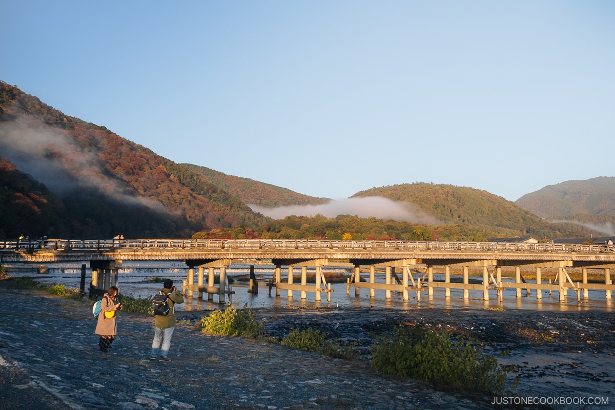 Arashiyama mountains and bridge covered with colorful autumn leaves at dawn