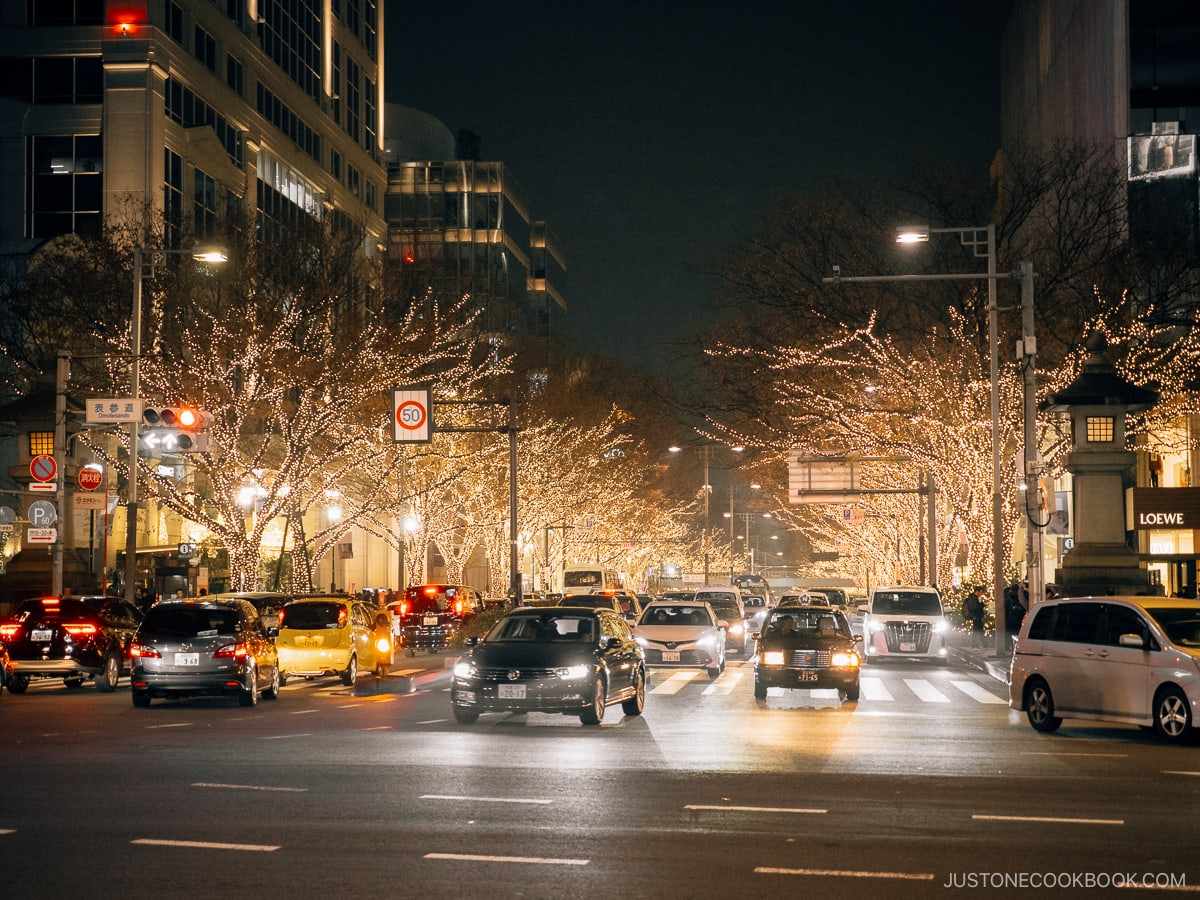 Busy intersection lined with illuminated trees