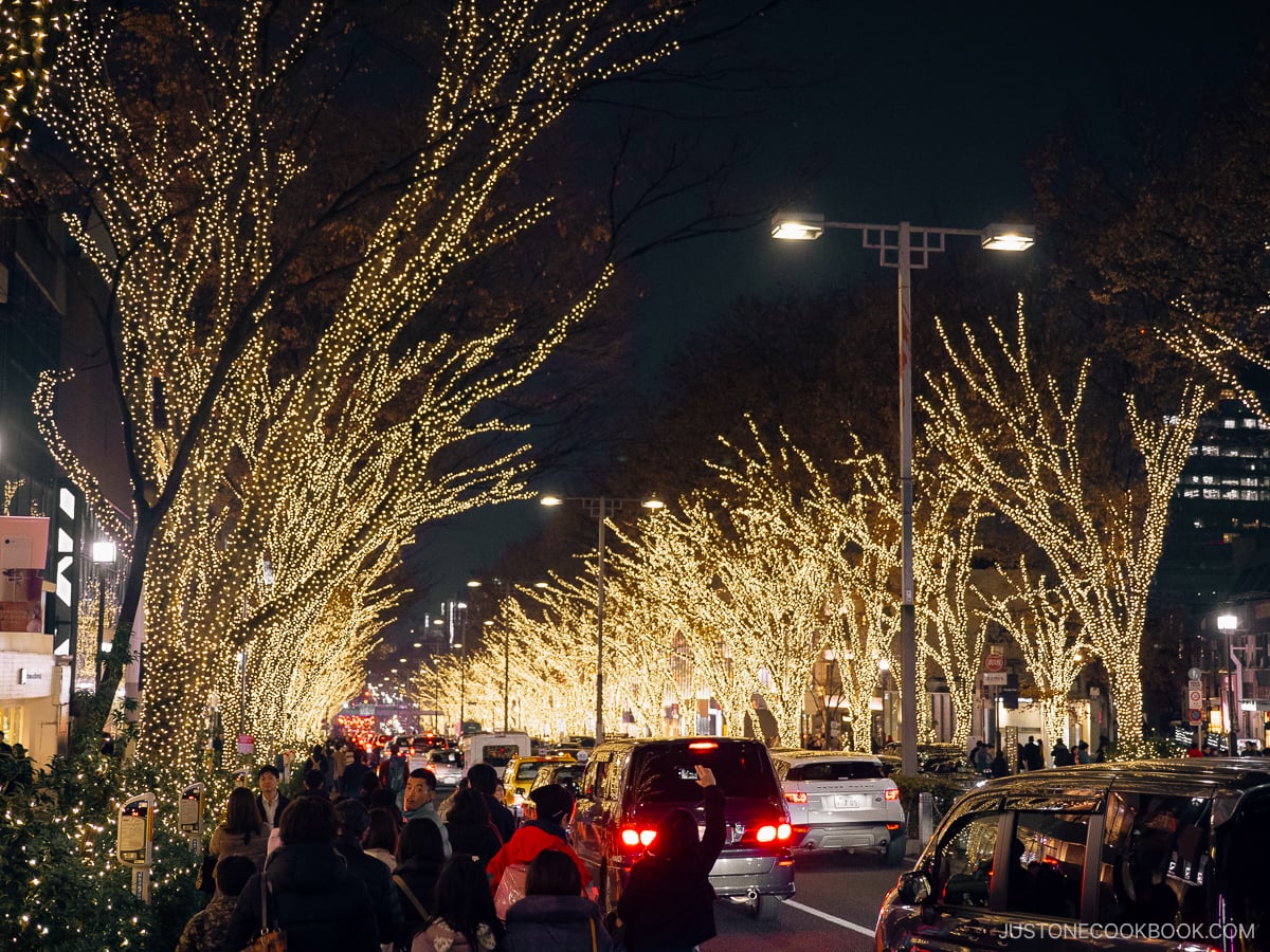 Busy road lined with illumiated trees.