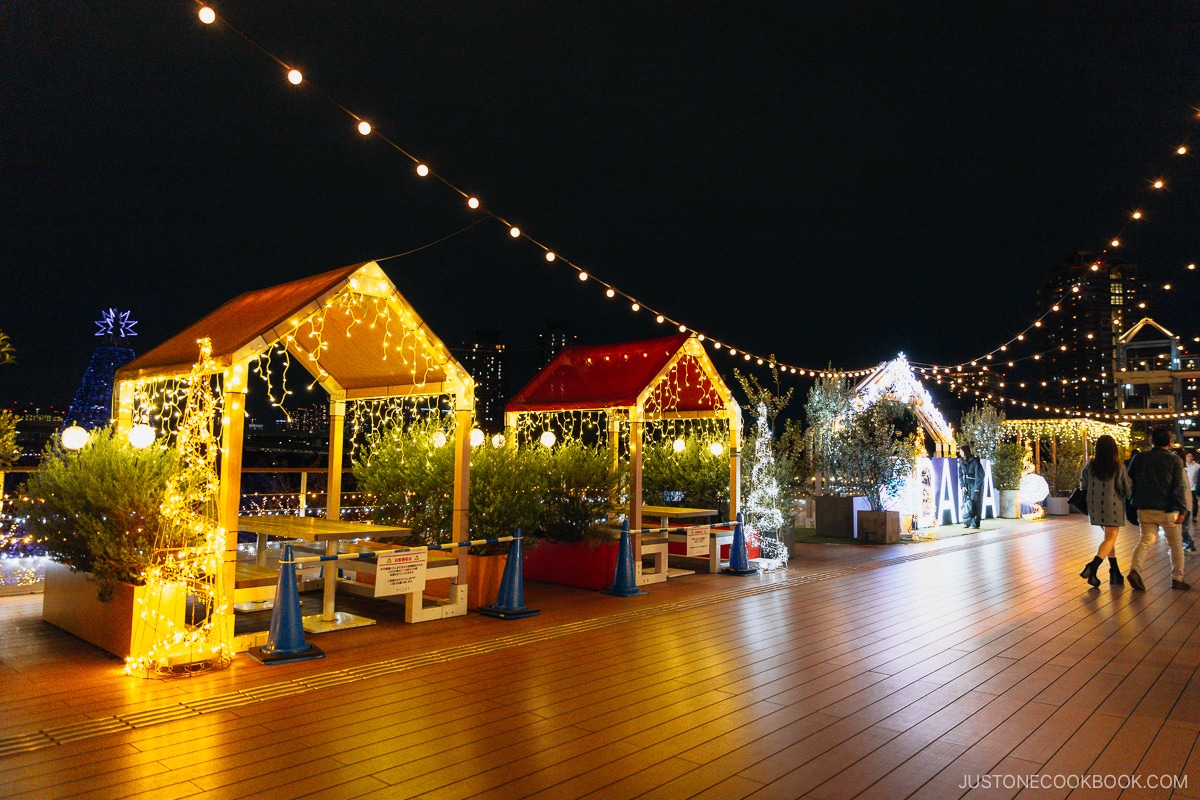 Small covered wooden seating draped in LED illuminations