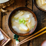 Japanese wooden soup bowls containing Daikon and Fried Miso Soup.