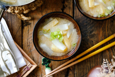 Japanese wooden soup bowls containing Daikon and Fried Miso Soup.