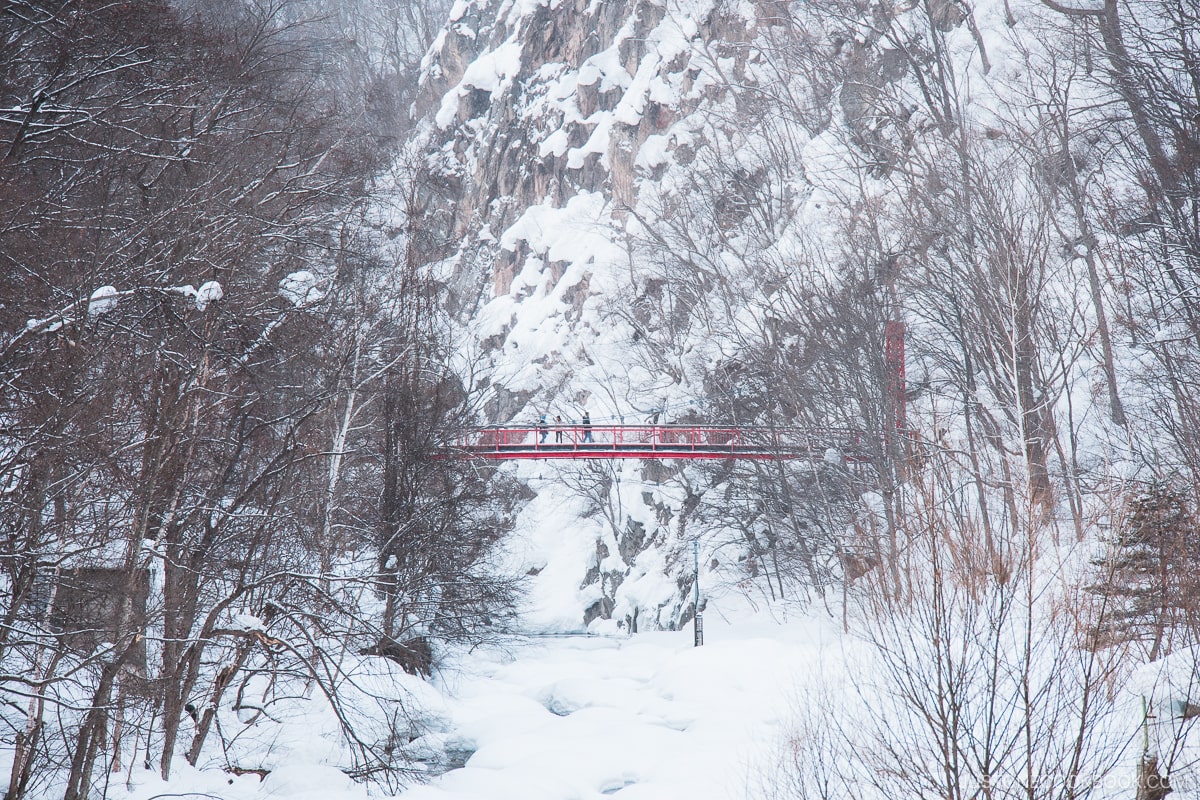 Jozankei red bridge in the mountains surrounded by snow