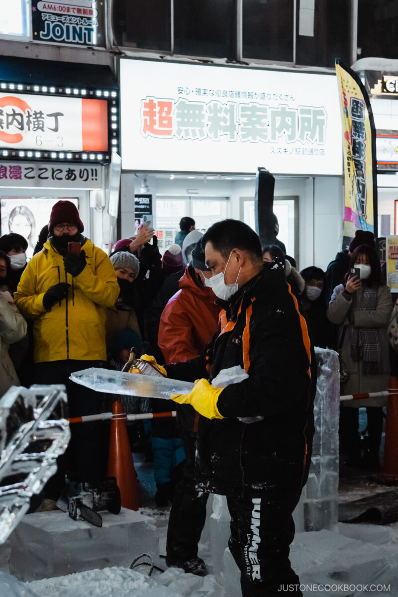 Person making an ice sculpture in Susukino at Sapporo Snow Festival