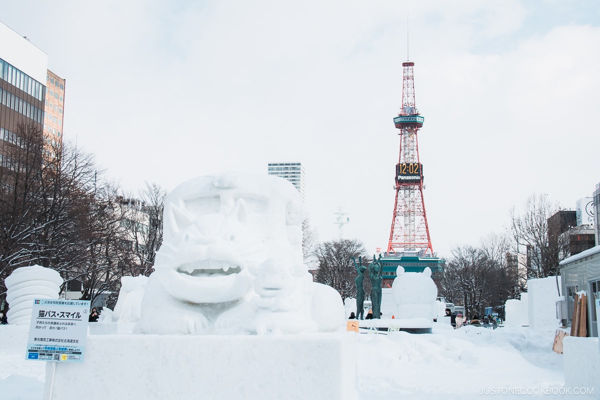 Snow sculpture of a Cat bus featured in Studio Ghibli, in Odori Park with Sapporo TV Tower in the background