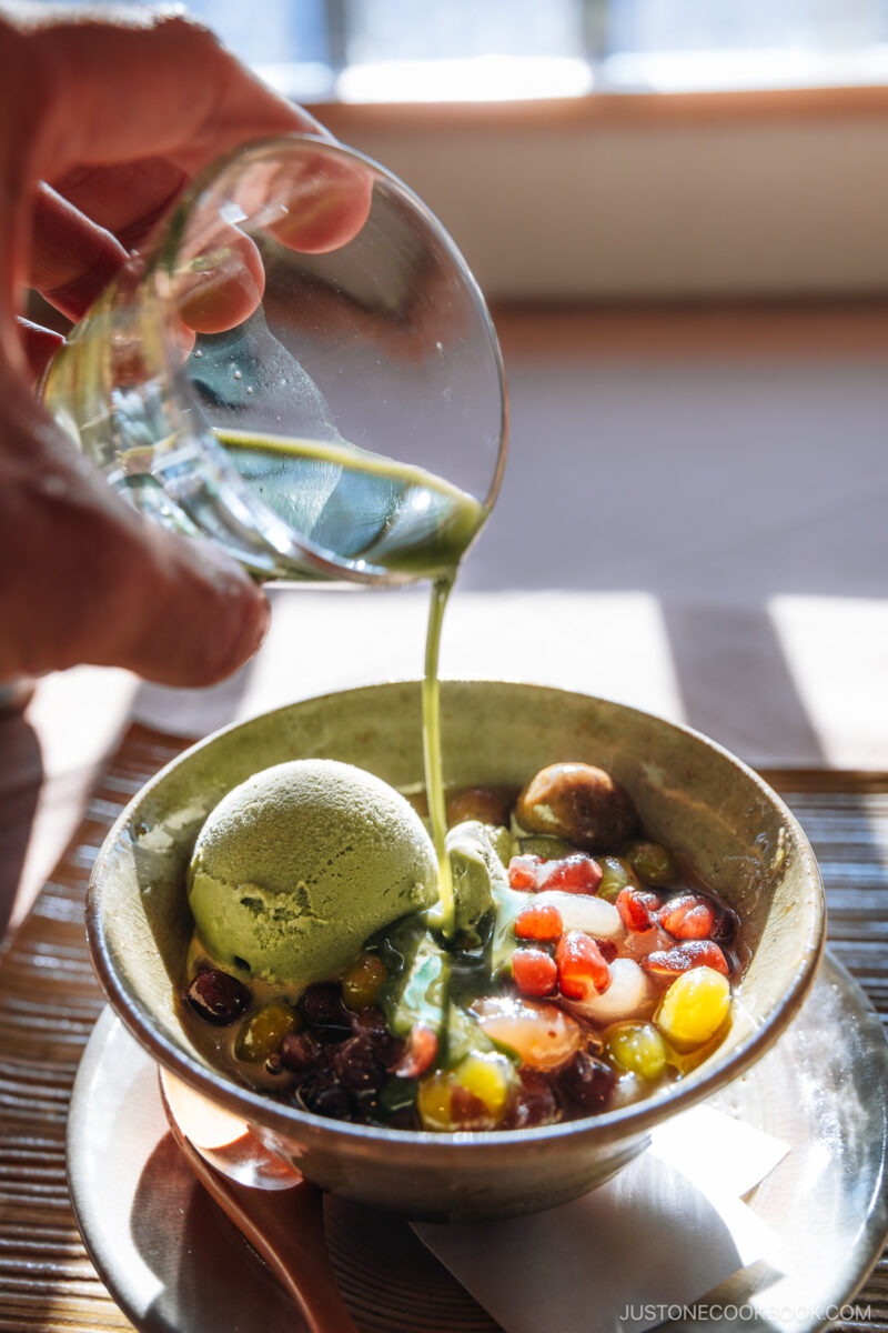 Matcha sauce being poured on top of a dessert