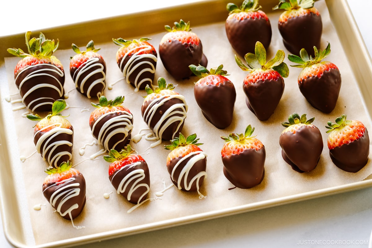 Chocolate covered strawberries on a baking sheet.